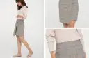 Kratka na spódniczce to ponadczasowy trend. Modelka prezentuje stylową, asymetryczną spódniczkę w kratkę, która z pewnością jest modna.