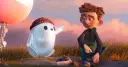Chłopiec i robot Ron, bohater jednej z warner bros bajek, siedzą na wzgórzu podczas zachodu słońca.