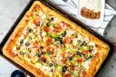 Pyszna pizza domowa na blachę z pieczarkami, papryką, oliwkami i pepperoni. Idealny przepis na szybki obiad.
