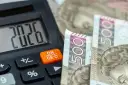 Kalkulator pokazuje 20,26, a obok leżą banknoty 500 zł. To może być odpowiedź na pytanie, ile zarabia pomocnik dekarza na godzinę.