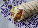 Pyszny kebab zawinięty w tortillę, z soczystym mięsem, chrupiącą sałatą, pomidorem, ogórkiem i czerwoną cebulą. Idealny przepis na szybki obiad.