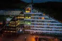 Nowoczesny hotel Klimczok Resort & Spa nocą, z oświetlonymi oknami i wejściem. Wiele pozytywnych hotel klimczok resort & spa opinie potwierdza jego urok.