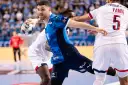 Piłkarz Wisły Płock w akcji przeciwko PSG. Zawodnik w niebieskiej koszulce z piłką w ręku, gotowy do rzutu.