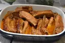 Pieczone żeberka w sosie w naczyniu żaroodpornym.