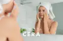 Kobieta z ręcznikiem na głowie aplikuje krem pod oczy, by pozbyć się ziemistej cery.