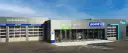 Façade d'un centre auto Point S avec des portes de garage et des panneaux indiquant les services (vidange, freins, pneumatiques, pare-brise).