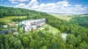 Hotel w otoczeniu zielonych lasów Gór Świętokrzyskich, z widokiem na dolinę.