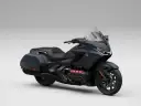 Ciemnoszary motocykl Honda Gold Wing z czarnym siedzeniem i kuframi, gotowy na dalekie podróże.