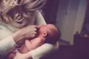 Delikatne dotknięcie palcem ust noworodka, gdy mama próbuje poradzić sobie z kryzysem laktacyjnym.