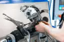 Mechanik naprawia turbosprężarkę, mocując ją imadłem. Widoczny jest zawór N75, kluczowy element sterujący.
