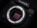 Zbliżenie na matrycę aparatu Fujifilm xh2s, lśniący metalowy pierścień mocowania obiektywu i czerwona kropka sygnalizująca montaż.