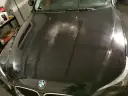 Na czarnej masce BMW widać liczne drobne rysy i zmatowienia, tworzące efekt "oczek na lakierze".