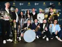 Bum bum orkiestar gotowy do zabawy! Muzycy z instrumentami dętymi i perkusją pozują do zdjęcia.