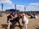 Trzy kobiety bawią się na festiwalu czaplinek pol and rock. W tle scena i tłum ludzi.