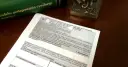 Zielona księga z tytułem "Kodeks postępowania cywilnego" i dokument z polami do wypełnienia.