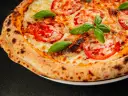 Pyszna pizza Margherita z pomidorami i bazylią, idealnie wypieczona w wysokiej temperaturze przez kilka minut.