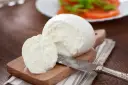 Świeża mozzarella na desce, gotowa do sałatki. Czy mozzarella jest wegetariańska? Tak, tradycyjnie tak!