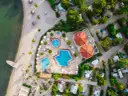 Widok z lotu ptaka na kemping z basenami i plażą. Widać tu podział na strefy: plażową, basenową i kempingową z kamperami.