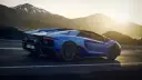 Niebieski Lamborghini Aventador pędzi po górskiej drodze. Choć trudno określić, ile pali Lamborghini Aventador, jego moc jest niezaprzeczalna.