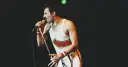 Freddie Mercury, jeden z najlepsi muzycy wszechczasów, śpiewa do mikrofonu na koncercie.