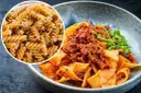 Pyszny makaron na redukcji z sosem bolognese. Widać też surowy makaron fusilli, idealny do zdrowych posiłków.