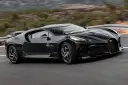 Czarny Bugatti La Voiture Noire pędzi po krętej drodze. Zastanawiasz się, ile kosztuje ten cud motoryzacji?