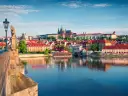Widok na Pragę z rzeką Wełtawą i Mostem Karola, z zamkiem na wzgórzu.
