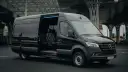 Czarny Mercedes Sprinter z otwartymi drzwiami, wnętrze z wygodnymi fotelami. Zastanawiasz się, ile kosztuje bus do Francji?