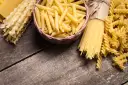 Różne rodzaje makaronu: penne, spaghetti, fusilli i faliste tagliatelle. Wybór między makaronem grahan a durum zależy od preferencji.