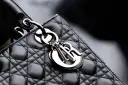Elegancka, pikowana torebka Lady Dior w kolorze czarnym, z metalicznym logo Dior.