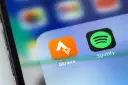 Ikona aplikacji Strava, idealna do śledzenia tras rowerowych, obok Spotify na ekranie smartfona.