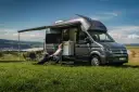 Mężczyzna odpoczywa przy kamperze VW California. Wymiary tego pojazdu pozwalają na komfortowe podróżowanie i biwakowanie.