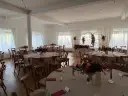 Elegancka sala weselna z okrągłymi stołami, kwiatami i świecami. Idealne miejsce, by wybrać najlepszą salę na wesele.