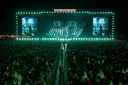 Ogromny tłum na koncercie Żywiec Męskie Granie. Na scenie artysta, a na telebimach jego wizerunek.