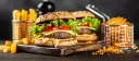 Dwa soczyste hamburgery z serem, sałatą i pomidorem, podane z frytkami.
