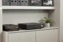 Czarny wzmacniacz zintegrowany Roksan K3 stoi obok zabytkowej maszyny do pisania.