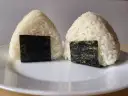 Dwa ryżowe onigiri z nori, gotowe do spożycia. Idealne nadzienie do onigiri sprawia, że są pyszne.