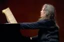 Martha Argerich, pianistka o argentyńskim pochodzeniu, gra na fortepianie, wpatrzona w nuty.