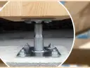 Metalowa kotwa do słupa drewnianego zamontowana na betonowym fundamencie.