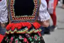 Kolorowy strój ludowy, ozdobiony koralikami i haftem, zapowiada radosne tańce ludowe.