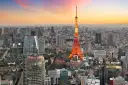 Widok na Tokio, jedno z 10 największych miast na świecie, z wieżą Tokyo Tower w pomarańczowych barwach o zachodzie słońca.