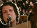 Kto śpiewał "Zegarmistrz światła purpurowy"? To on, z mikrofonem i gitarą, na tle orkiestry.