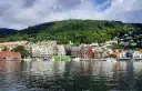 Kolorowe kamienice nad wodą, zielone wzgórze w tle – idealne miejsce, by zobaczyć, co zwiedzić w Bergen.