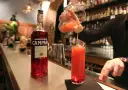 Barman nalewa drink z Campari do szklanki. Aperol kontra Campari - wybór należy do Ciebie!