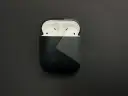 AirPods in einer schwarzen Hülle mit grauem geometrischem Muster.