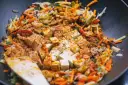 Smażone warzywa po chińsku z tofu i ryżem, doprawione kurkumą i papryką, gotowe do podania.