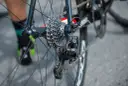 Zbliżenie na tylną przerzutkę i kasetę roweru szosowego.