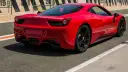 Czerwone Ferrari 458 Italia na torze wyścigowym, widok z tyłu.