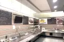 Interior of a restaurant with a display counter, menu boards, and food images.