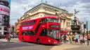 Czerwony piętrowy autobus w Londynie na tle Piccadilly Circus.